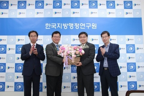 왼쪽에서 두 번째 한국지방행정연구원 윤태범 원장이 왼쪽에서 세 번째 국립과학수사연구원 박남규 원장으로부터 꽃바구니를 전달받고 있다