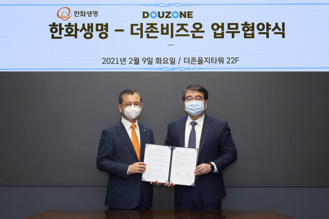 더존비즈온과 한화생명보험이 사업 협력 및 공동 마케팅 추진을 위한 업무제휴 양해각서를 체결한 가운데 왼쪽부터<br>
한화생명보험 여승주 대표와 더존비즈온 김용우 대표가 업무협약서를 교환하고 있다
