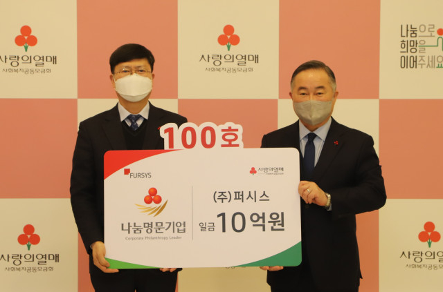 왼쪽부터 퍼시스 배상돈 대표와 사랑의열매 예종석 회장이 사회복지공동모금회 나눔명문기업 100호 회원 가입식에서<br>
기념촬영을 하고 있다