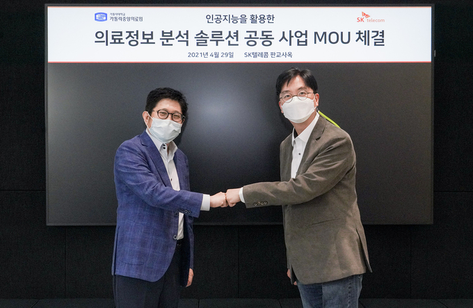 왼쪽부터 가톨릭중앙의료원 김대진 정보융합진흥원장과 SKT 김윤 CTO가 의료 AI 솔루션 개발을 위한 MOU 체결식에서 기념 촬영을 하고 있다.