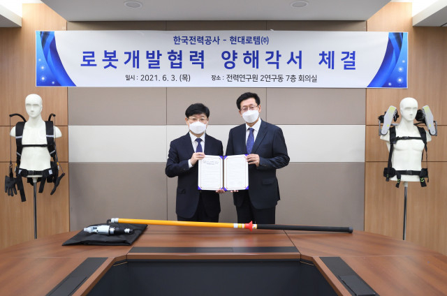 왼쪽부터 송기욱 한전 전력연구원 융복합프로젝트연구소장과 안경수 현대로템 디펜스솔루션사업본부장이 체결식에서 기념 촬영을 하고 있다.