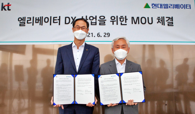 왼쪽부터 KT 박종욱 경영기획부문장 사장과 현대엘리베이터 송승봉 대표이사가 체결식에서 기념 촬영을 하고 있다.