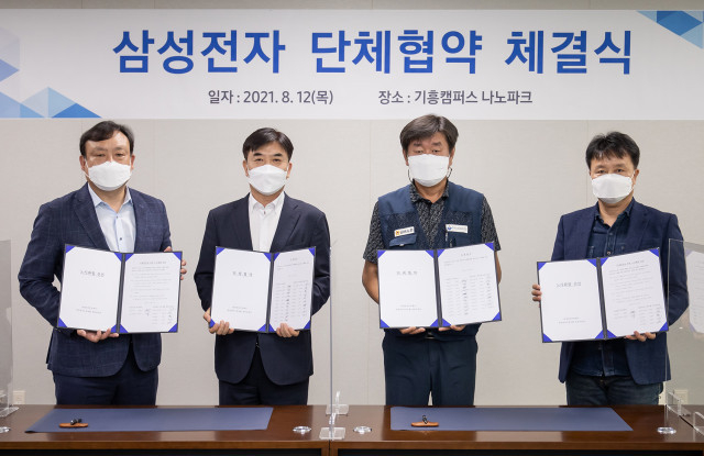 왼쪽부터 삼성전자 DS부문 인사팀장 최완우 부사장, 김현석 대표이사, 한국노총 금속노련 김만재 위원장, 삼성전자사무직노동조합 김항열 위원장이 체결식에서 기념 촬영을 하고 있다.