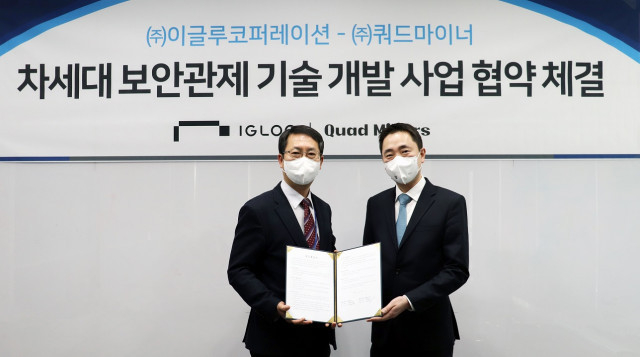 왼쪽부터 조창섭 이글루코퍼레이션 부사장과 박범중 쿼드마이너 대표가 ‘차세대 보안관제 기술 개발 사업 공동 추진을 위한<br>
업무 협약서’를 교환하고 기념촬영을 하고 있다