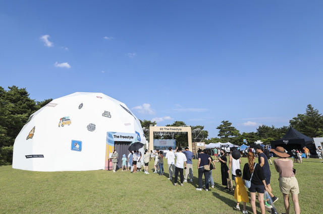 강원도 양양에서 진행된 ‘2022 고아웃 캠프’ 잔디광장 내 삼성 더 프리스타일 더 프리돔(The FreeDOME) 체험존 전경. 더 프리돔은 더 프리스타일 제품 디스플레이 공간부터 이색 포토존, 휴식 공간, 게임존 등 다채로운 체험 공간으로 운영된다. 더 프리돔을 찾은 캠퍼들이 부스 앞에서 입장을 대기하고 있다.