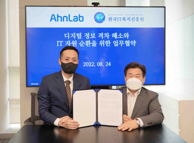 왼쪽부터 안랩 지속가능경영팀 인치범 상무와 한국IT복지진흥원 정일섭 원장이 업무 협약식에서 기념 촬영을 하고 있다