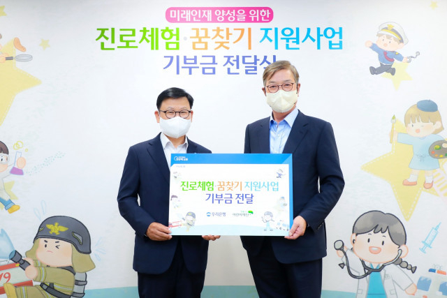 왼쪽부터 이원덕 우리은행장이 황영기 초록우산어린이재단 회장과 기념촬영을 하고 있다.