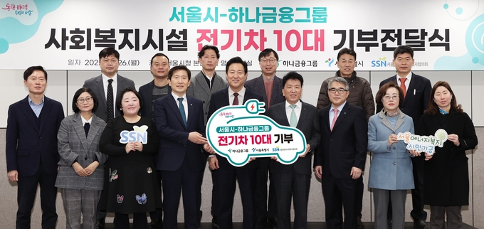 함영주 하나금융그룹 회장(사진 오른쪽에서 네번째)과 오세훈 서울시장(사진 오른쪽에서 다섯번째)이 친환경 전기 차량을 지원받은 사회복지시설 기관장들과 함께 기념 촬영을 하고 있다.