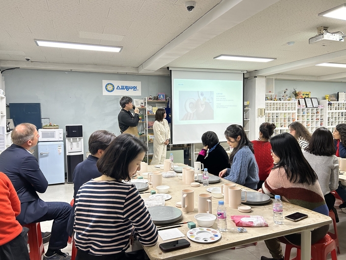 주한프랑스대사관 상무관실-비즈니스 프랑스 임직원이 발달장애인 강사의 설명을 듣고 있다