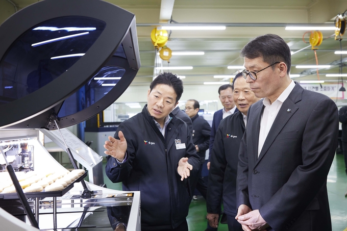 14일 김성태 IBK기업은행장(오른쪽)이 경기도 양주시에 위치한 디지아이를 방문해 최동호 대표(왼쪽)로부터 작업공정에 관한 설명을 듣고 있는 모습.