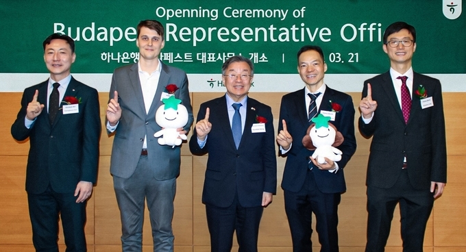 이 날 개소식에 참석한 홍규덕 주헝가리 한국대사(사진 가운데), 이승호 하나은행 유럽중동지역본부장(사진 왼쪽에서 네번째), 피터 사트마리(Peter Szatmari) 헝가리 투자청 수석국장(사진 왼쪽에서 두번째), 김행범 헝가리 한인상공회의소 회장(사진 왼쪽 첫번째), 이기훈 하나은행 부다페스트 사무소장(사진 왼쪽에서 다섯번째)이 기념촬영을 하고 있다. 