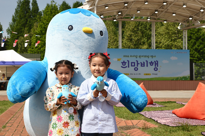 소아암어린이 완치 희망행사 (2024.4.27.(토) / 서울 강남구 일원동 마루공원) (소아암 어린이 완치 희망행사에 참여한 어린이들이 새마을금고 블루원정대 캐릭터 미루와 사진촬영을 하고 있다. 