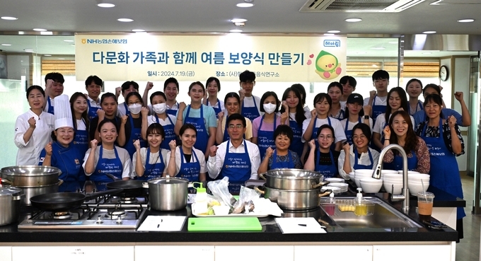 농협손해보험 장경민 부사장(사진 앞줄 왼쪽 다섯 번째)과 헤아림 봉사단, 다문화 가족 이주여성들이 기념촬영을 하고 있다. 