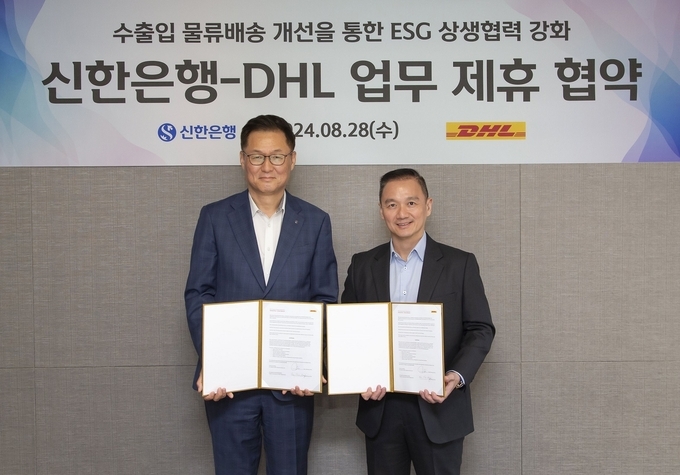 지난 28일 서울시 마포구 소재 DHL코리아 본사에서 진행된 ESG 상생협력 강화 업무협약식에서 신한은행 이해창 외환사업본부장(왼쪽)과 DHL 융츈위(Yung Chiun Ooi) 수석 부사장이 협약식 이후 기념촬영하는 모습.