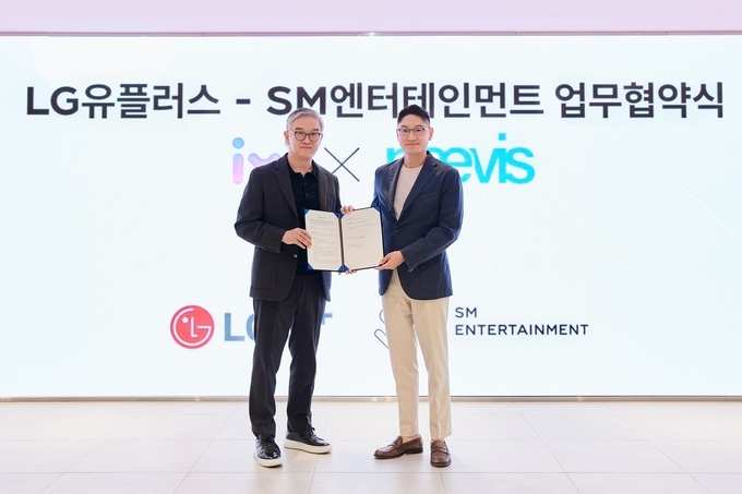 LG유플러스 정수헌 컨슈머부문장(왼쪽), SM엔터테인먼트 탁영준 대표(오른쪽)가 29일 서울 성수동 SM 사옥에서 업무협약식을 진행하고 기념사진을 촬영하고 있는 모습. 