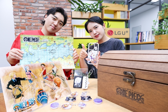 LG유플러스 직원이 아이폰16 원피스 25주년 기념 한정판 굿즈를 소개하는 모습.