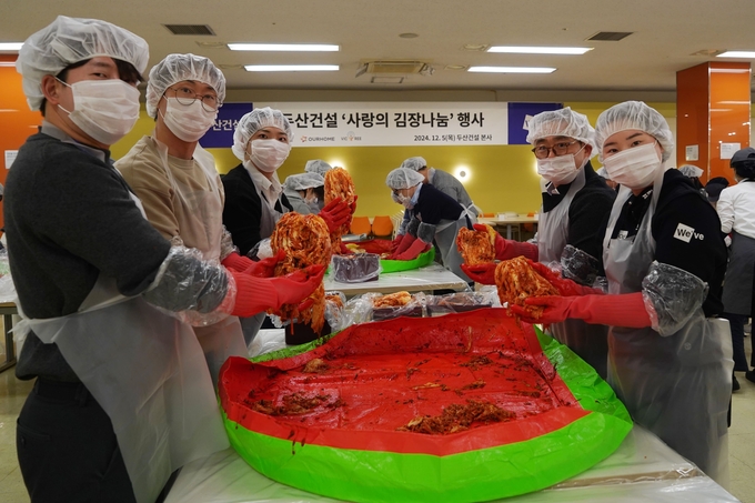 두산건설 임직원들이 김장을 실시하고 있다. (우측 두번째) 이정환 대표이사, (우측 첫번째) 임희정 프로