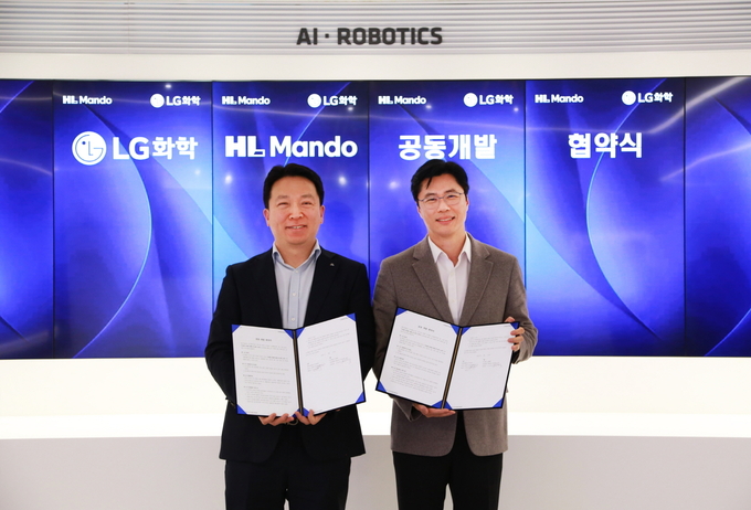 왼쪽부터 HL만도 센터장 최한규 상무와 LG화학 전자소재 사업부장 고경덕 상무가 업무협약식을 마치고 기념 촬영을 하고 있다.
