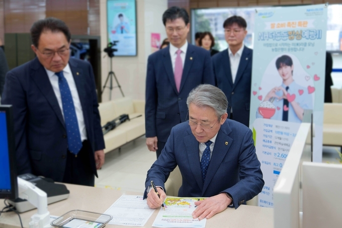 12일 농협은행 본사에서 강호동 농협중앙회장이 'NH더든든밥심예금Ⅱ' 1호 가입을 하고 있다.