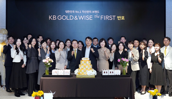 지난 22일(화) KB GOLD&WISE the FIRST 반포에서 열린 1주년 기념행사에서 KB GOLD & WISE the FIRST 반포(KB국민은행) 정은영 상무(앞줄 왼쪽 다섯번째), KB국민은행 박병곤 영업그룹 이사부행장(앞줄 왼쪽 여섯번째), KB증권 이홍구 대표이사(앞줄 왼쪽 일곱번째), KB GOLD & WISE the FIRST 반포(KB증권) 김희경 센터장(앞줄 왼쪽 여덟번째)을 비롯한 임직원들이 기념촬영을 하고 있다.