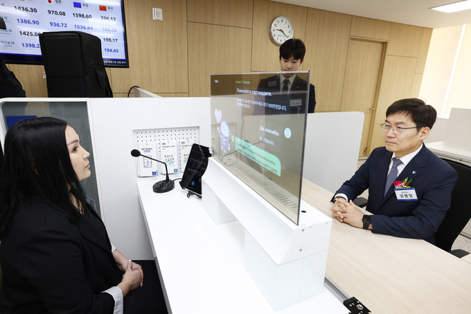 김형일 IBK기업은행 전무이사(오른쪽)가 13일 경기도 안산시에 위치한 기업은행 안산외국인금융센터에서 실시간 통번역서비스 시스템을 시연하고 있다.