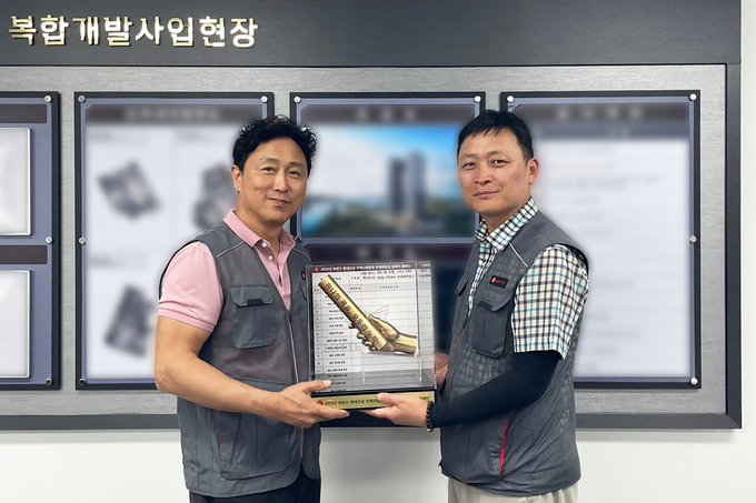 롯데건설 주택안전팀 이승환 상무(왼쪽)가 현장소장에게 ‘안전 바통’을 전달하고 있다.