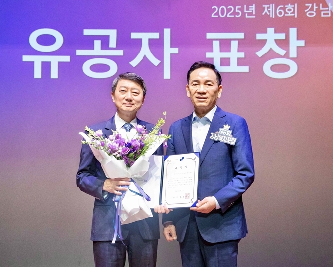 11일 서울 강남구 역삼문화센터에서 진행한 ‘제6회 강남복지포럼’에서 장호진 현대지에프홀딩스 사장(사진 왼쪽), 조성명 강남구청장(사진 오른쪽)이 표창 수여식을 마치고 기념사진을 촬영하고 있다.