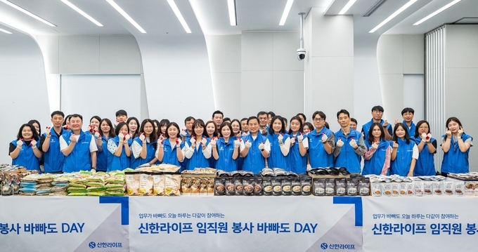 지난 12일 신한라이프 임직원들이 서울시 중구 본사에서 후원물품 포장 봉사활동에 앞서 기념 촬영을 하고 있다.