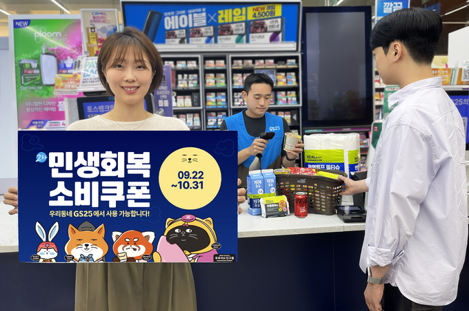 GS25에서 행사 상품을 구입하는 고객 옆에, 모델이 홍보물을 들고 있다.