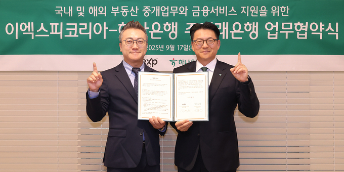 이날 행사에 참석한 정철 하나은행 중앙영업본부 지역대표(사진 오른쪽)가 김성환 이엑스피코리아 부동산중개법인㈜ 한국법인 총괄대표(사진 왼쪽)와 함께 업무협약서를 들고 기념촬영을 하고 있다.