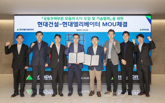 2일(목) 서울 종로구 현대건설 본사에서 현대건설 윤정일 구매본부장(오른쪽에서 네번째)과 현대엘리베이터 조 재천 대표이사(왼쪽에서 네 번째)를 비롯한 관계자들이 모듈러 E/V 도입 및 기술협력 업무협약을 체결한 후, 기념사진을 촬영하고 있다.