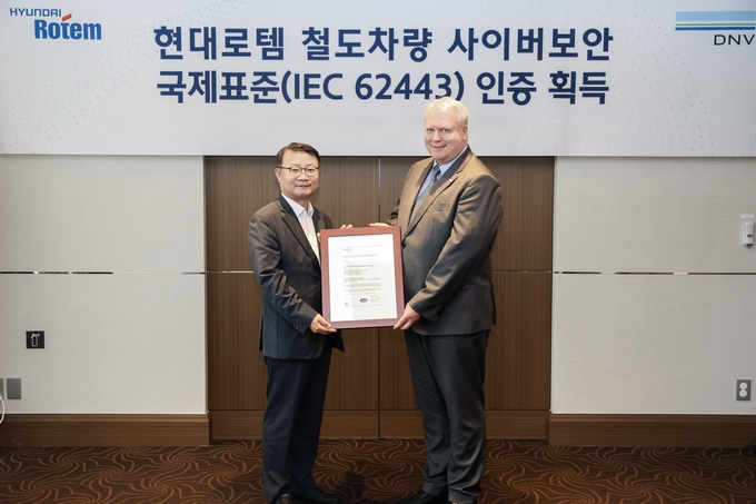왼쪽부터 이원상 현대로템 RS기술리더와 비달 도로넨(Vidar Dolonen) DNV 명예영사가 제품 인증서를 들고 기념 촬영을 하고 있다.